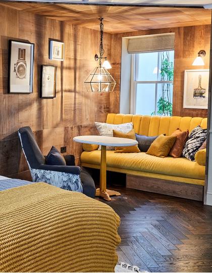 A yellow-toned hotel room at The Lost Poet, a hotel near Portobello Road Market
