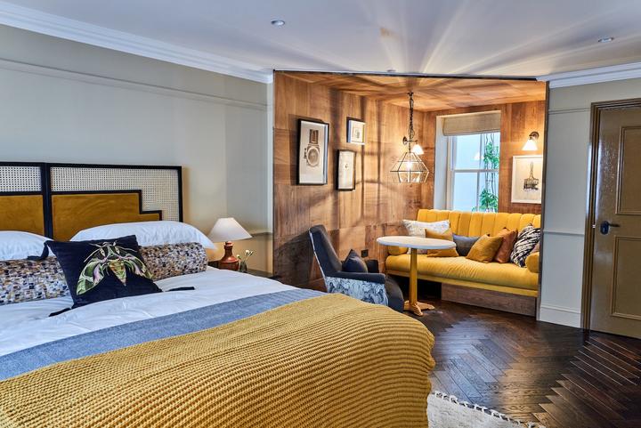 A yellow-toned hotel room at The Lost Poet, a hotel near Portobello Road Market